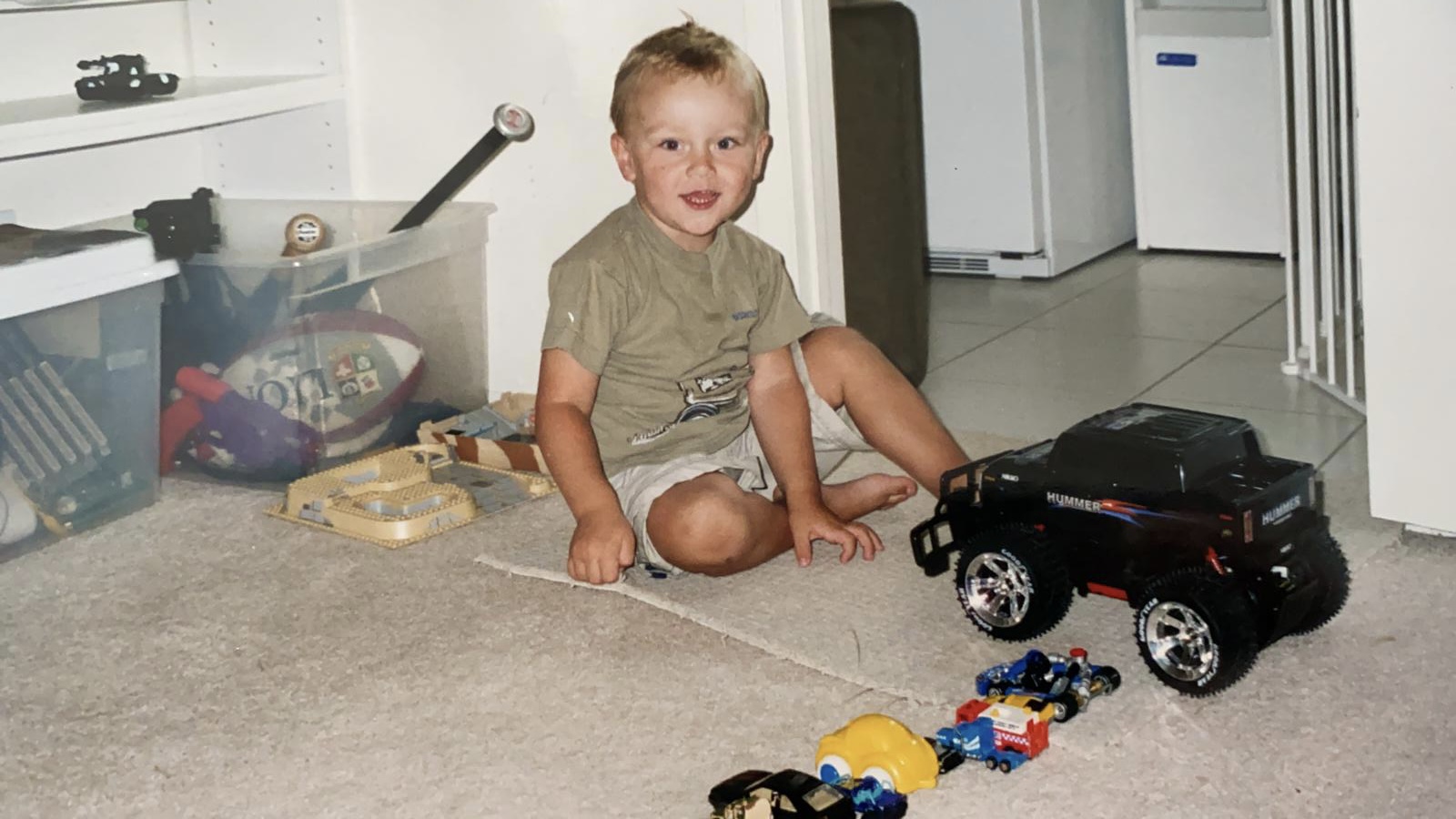 Tyson as a toddler surrounded by toy cars